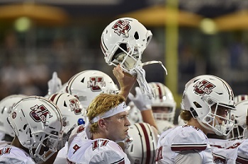 football player raising helmet