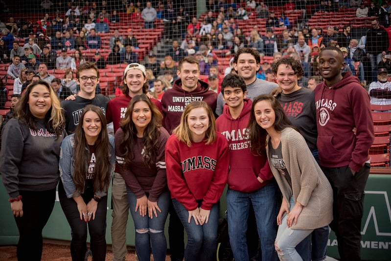 group of umass alumni on field at fenway park