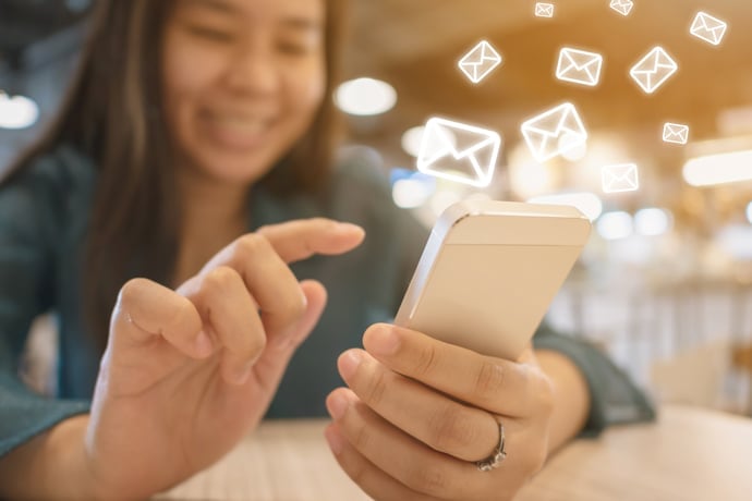 Person using phone with illustrations of envelopss