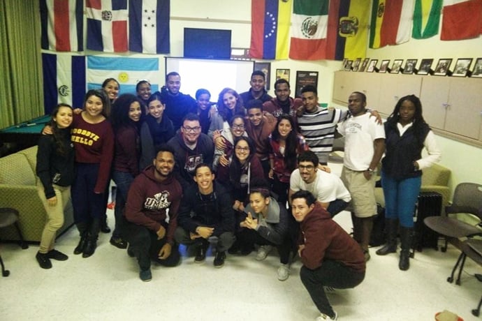 Group photo of Latino group with flags in background